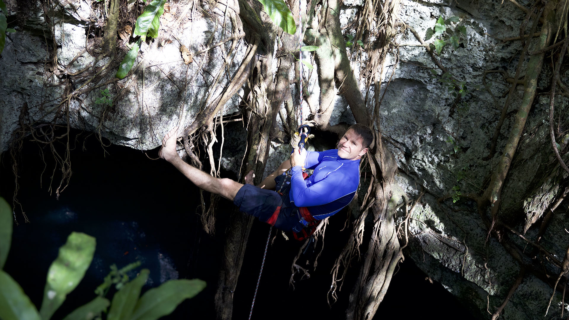 Image of Steve Backshall abseiling down a cenote.