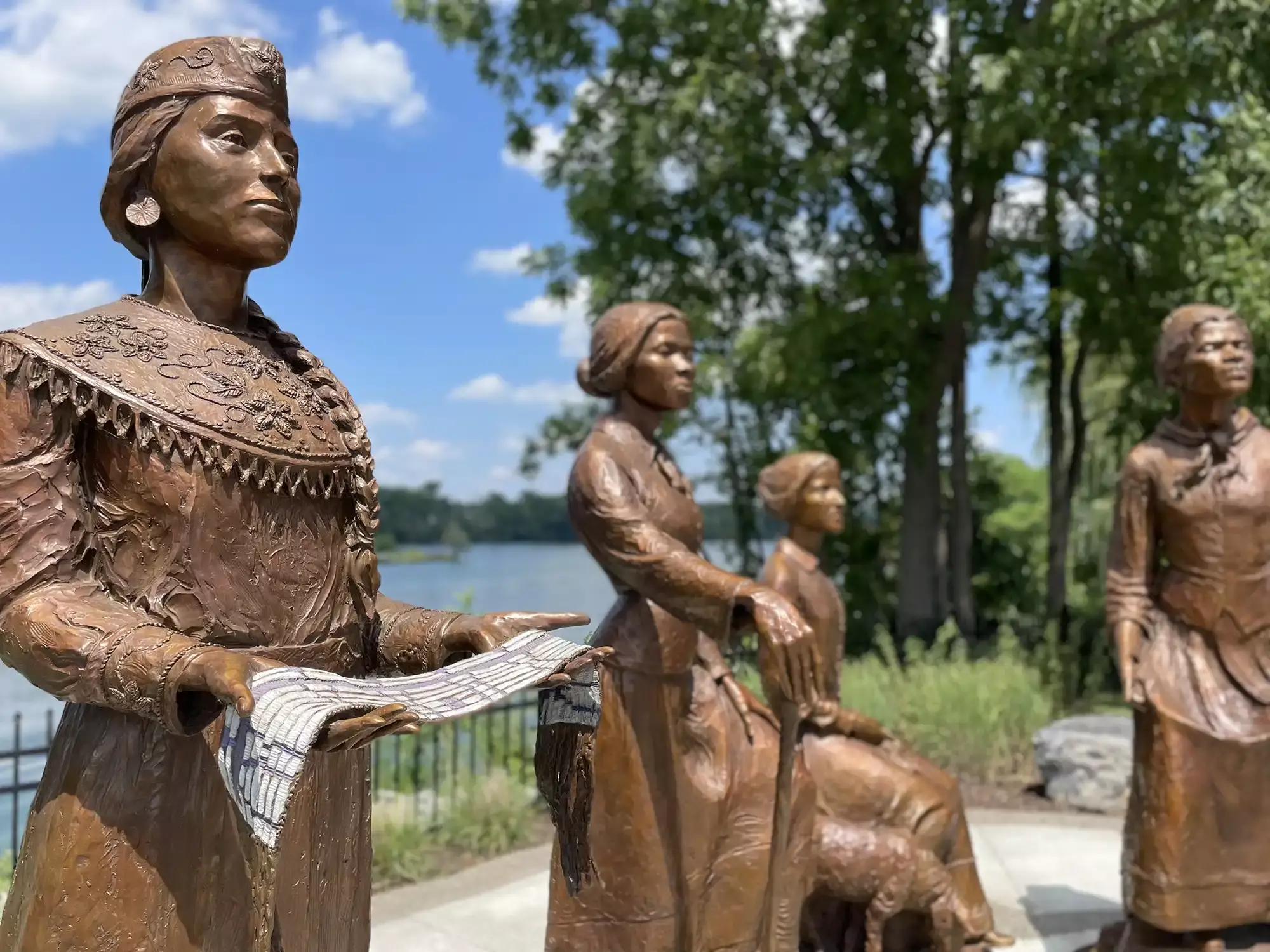 Ripples of Change Monument, Seneca Falls, NY commissioned by the U.S. Women's Suffrage Centennial Commission on the undertold contributions to Women's Suffrage. Laura Cornelius Kellogg (Oneida) stands holding the Haudenosaunee Women's Nomination Belt alongside Harriet Tubman, Martha Coffin Wright and Sojourner Truth.
