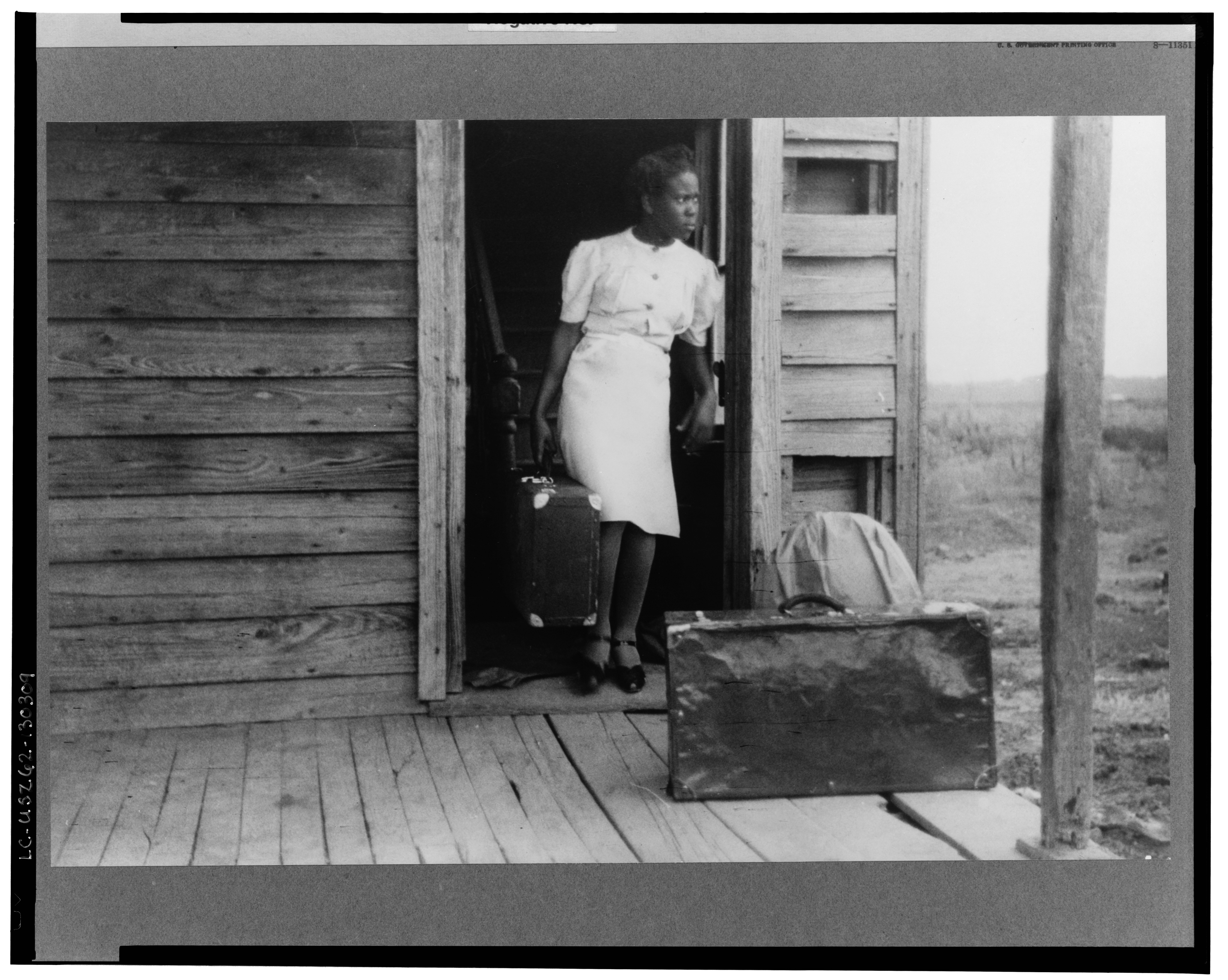 Florida migrant bringing her luggage out in preparation for a trip from Belcross, North Carolina to another job at Onley, Virginia.