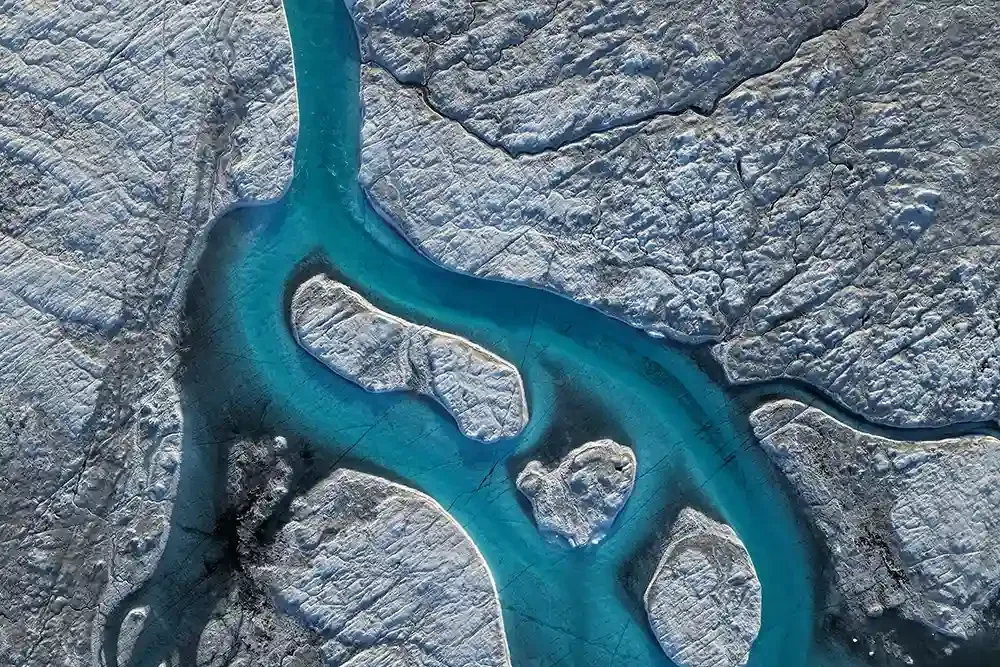 Aerial photo of glacial meltwater entering a moulin